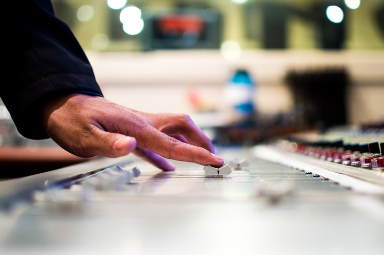 A closeup of a mixing console in a recording studio control room.