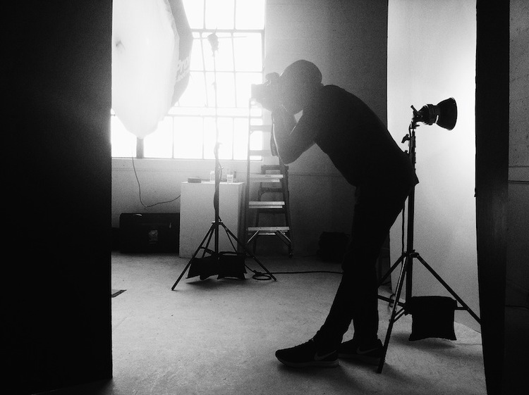 Ike Edeani, who uses MakeSpace for valet storage in NYC, takes a photo in a photography studio.