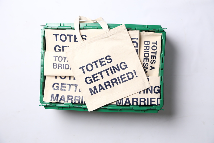The green MakeSpace storage bin of Brooklyn-based event and wedding planner Jove Meyers contains decorations, supplies, and "Totes Getting Married!" tote bags.
