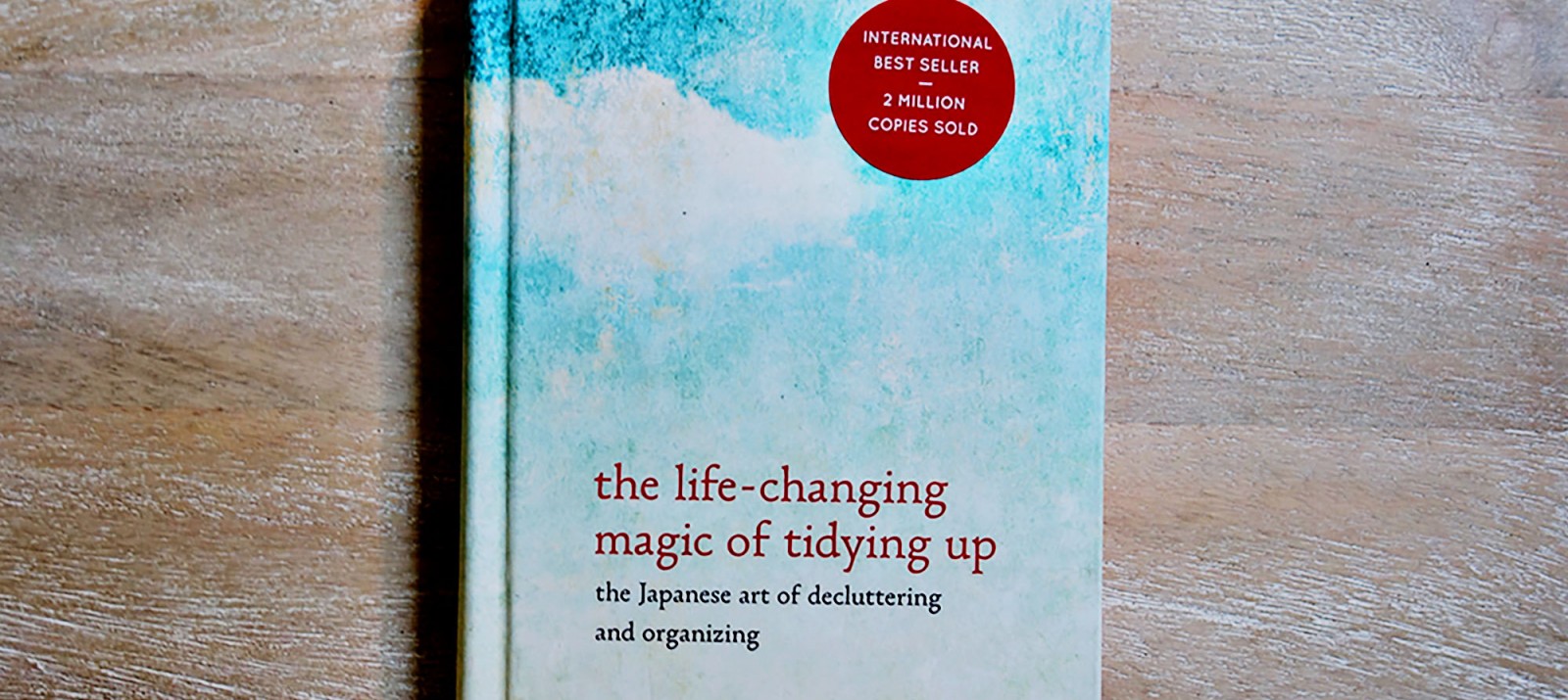 Marie Kondo The Life-Changing Magic of Tidying Up book on a wooden surface.