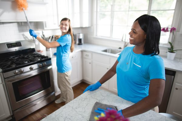 2 merry maids cleaning a kitchen