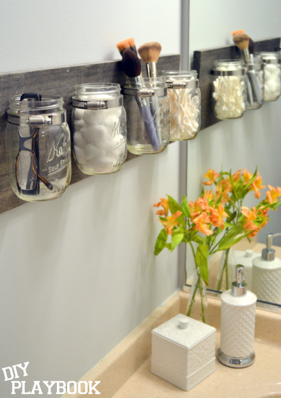 A DIY mason jar organizer is the best bathroom storage for toiletries,  brushes, eyeglasses, and plants in a small apartment.