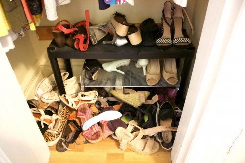 An unorganized, cluttered bedroom closet with shoes scattered everywhere.