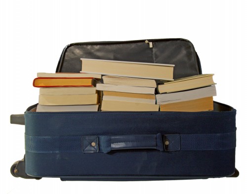 Rolling luggage filled with stacks of books makes packing and moving to a new apartment simpler.