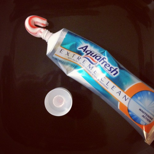 Before packing toothpaste, put plastic wrap on the tube's opening and then seal the cap.