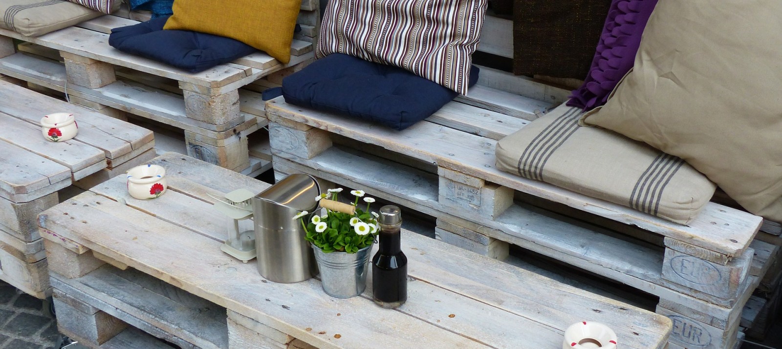 DIY wood pallet patio furniture with colorful cushions and storage space.