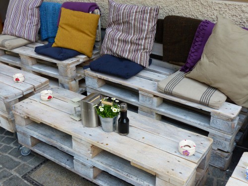 DIY wood pallet patio furniture with colorful cushions and storage space.