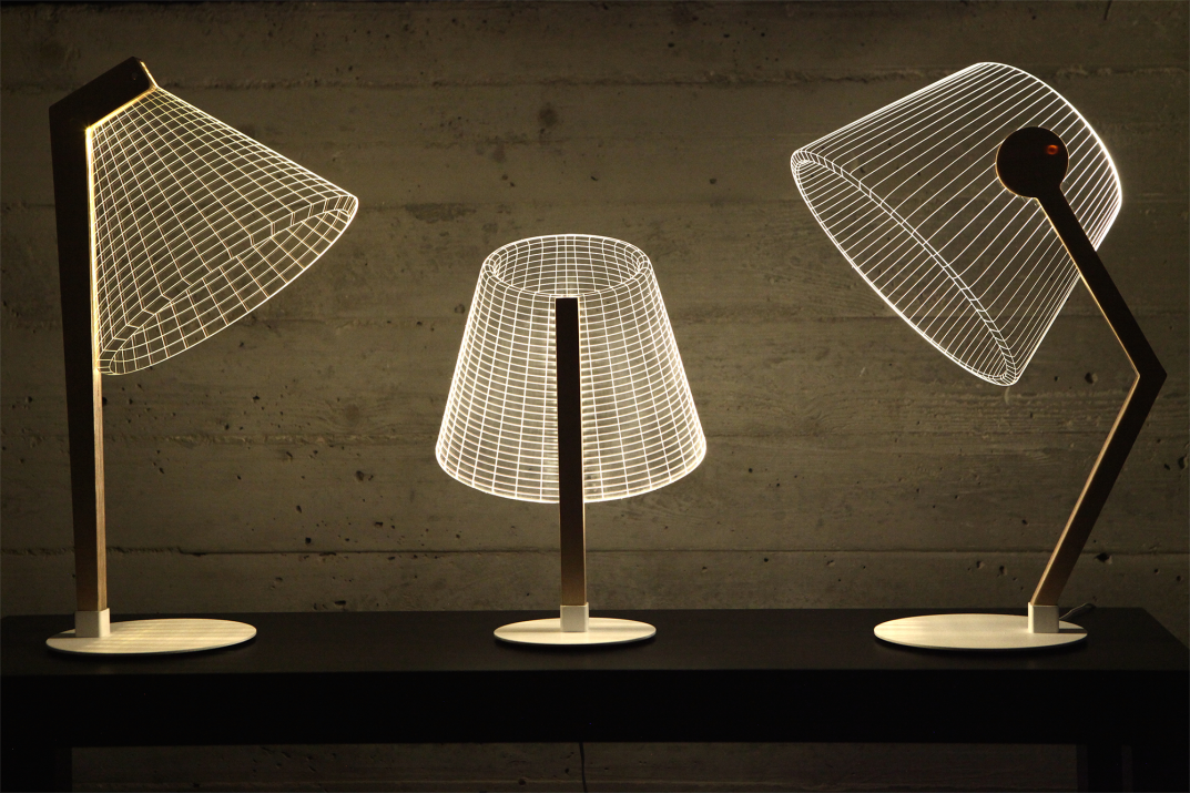 Three Studio Cheha 2D/3D BULBING lamps, the DESKi, CLASSi, and ZIGGi are on a desk in a small apartment.