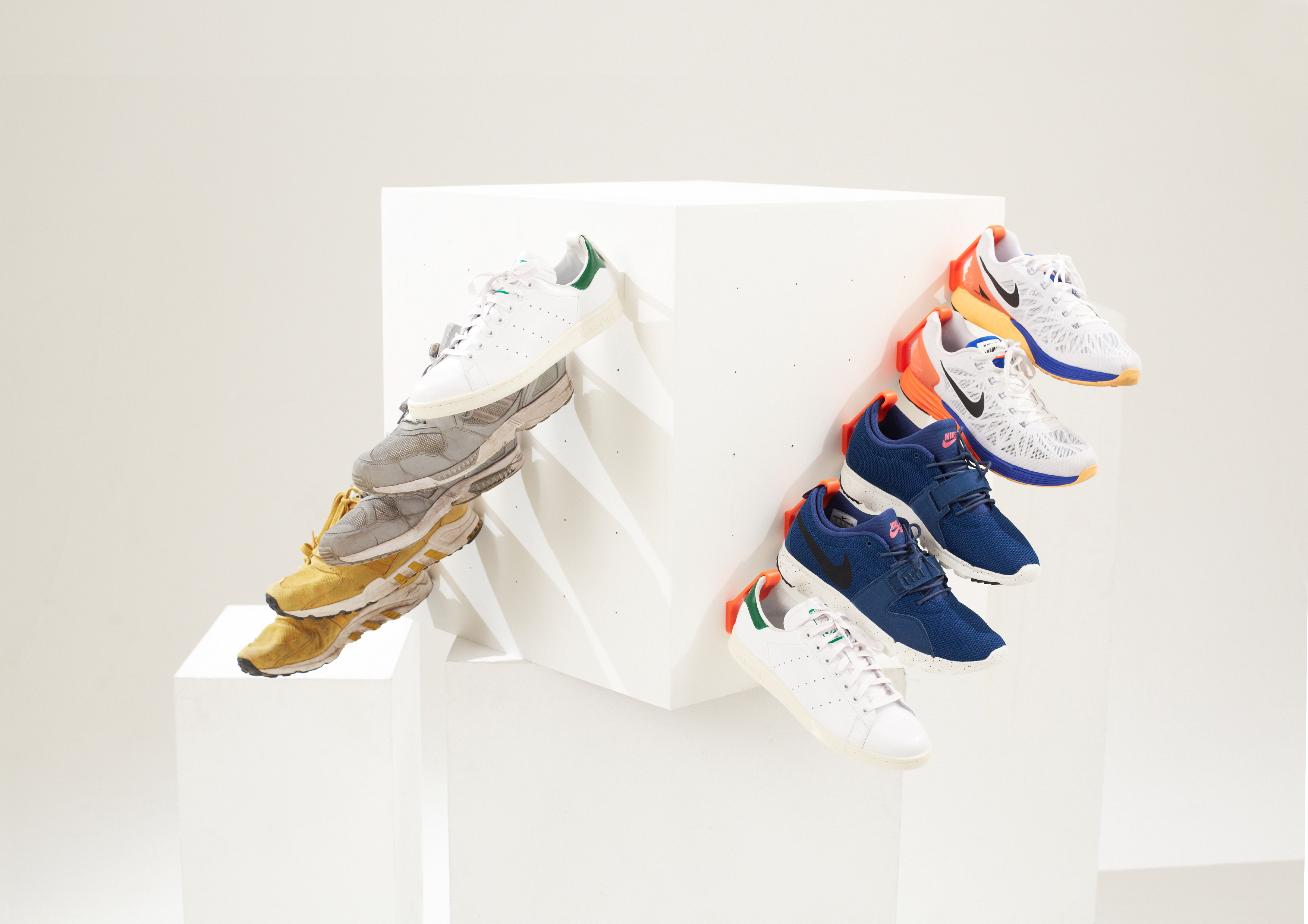 10 Staeckler shoe storage hooks are mounted to a white cube and hanging 5 pairs of sneakers.
