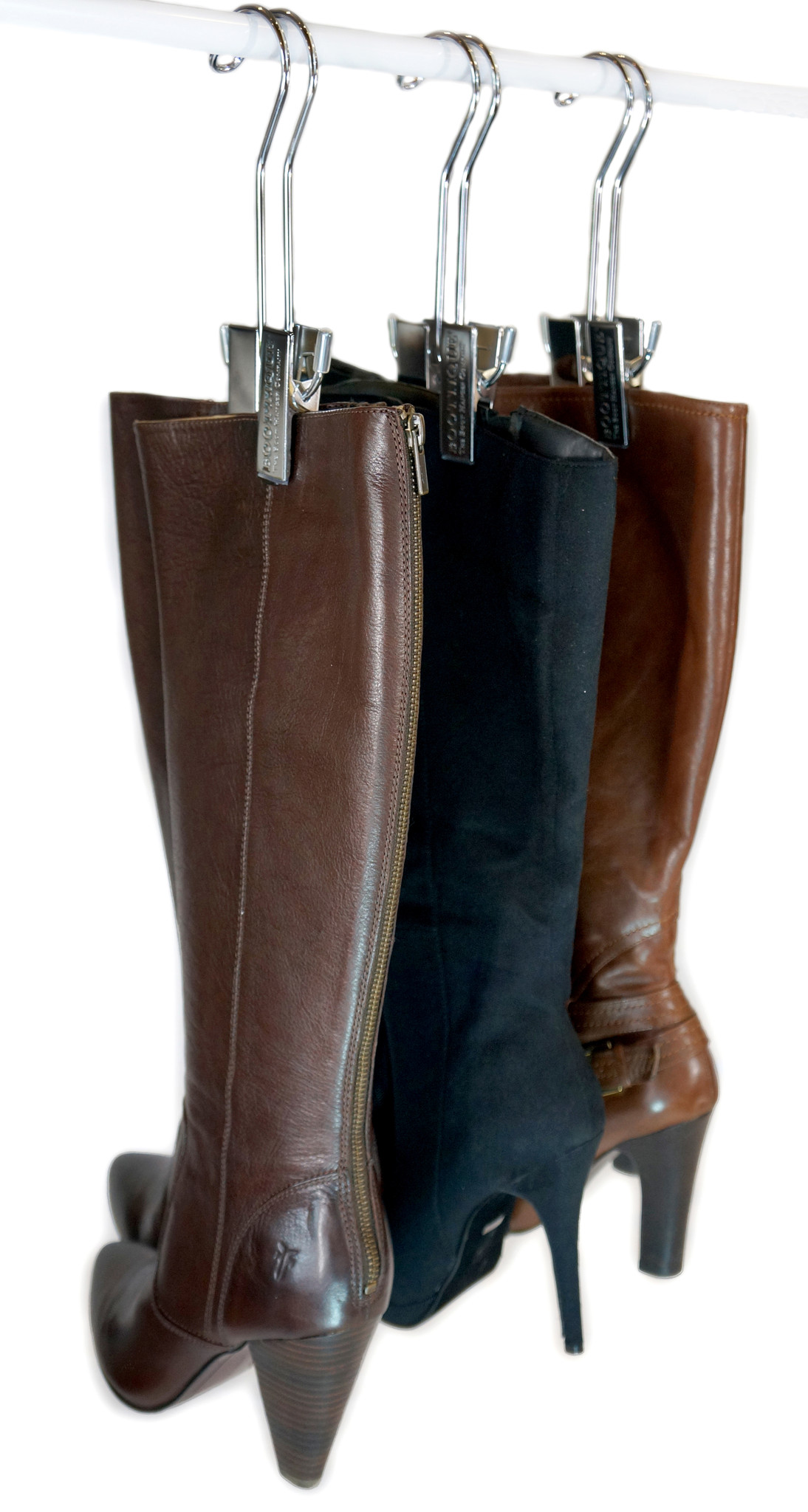 3 silver Bootique Boot Hangers are organizing 2 brown boots and 1 black boot on a closet rod.