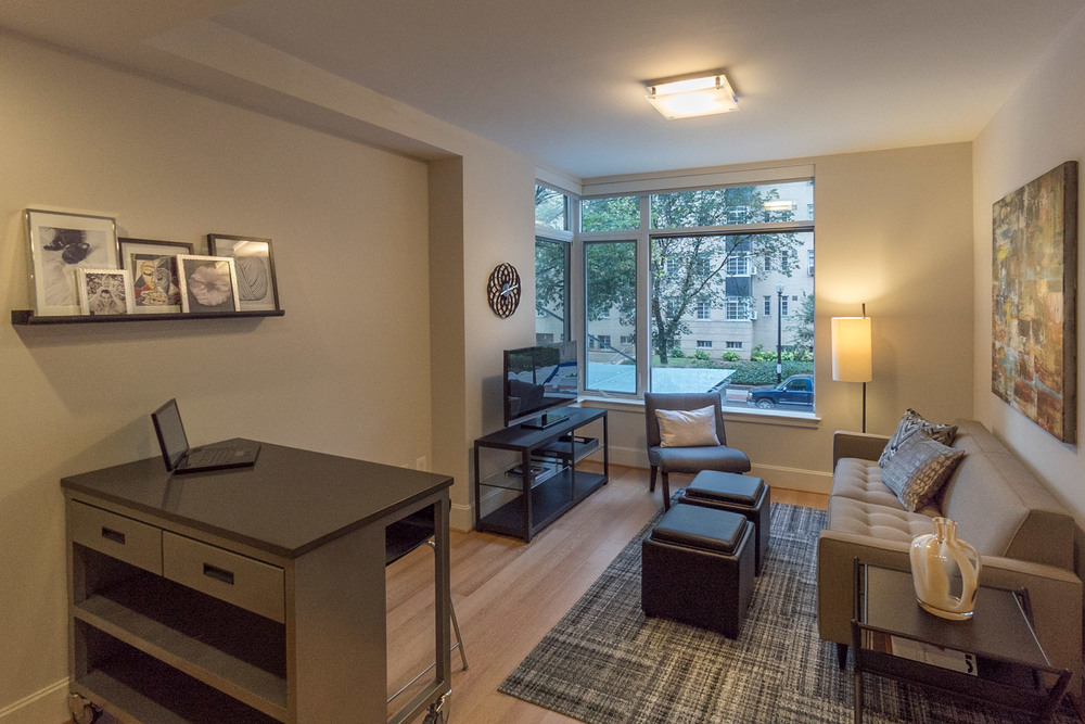 Storage ottomans, a rolling desk with drawers, and other space-saving furniture inside of one of The Drake's micro-apartments in Washington, DC.