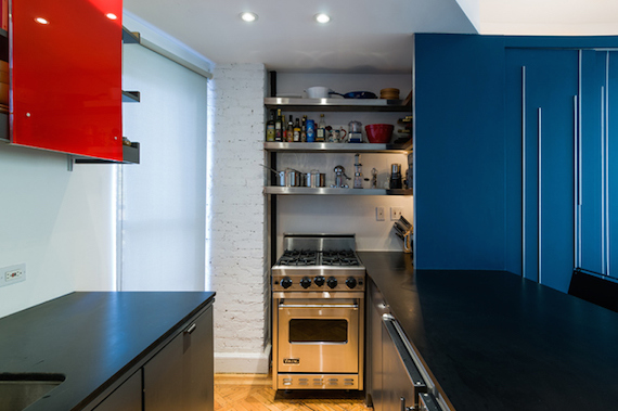 The kitchen inside of Unfolding Apartment, a tiny studio in Manhattan NYC that has a big blue piece of multipurpose furniture with storage.