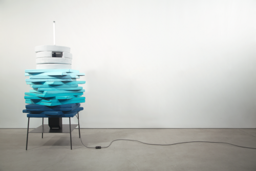 Blue and white Pile cushions are stacked on a sleek steel coffee table.