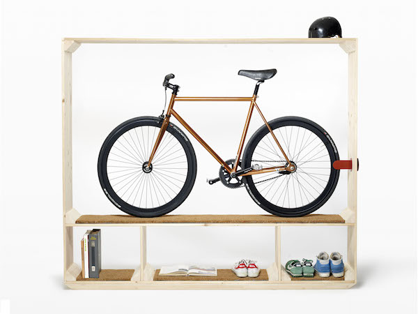 A wooden Post Fossil Shoes, Books and a Bike is storing an orange road bike, a black bicycle helment, and multiple shoes and books on shelves.
