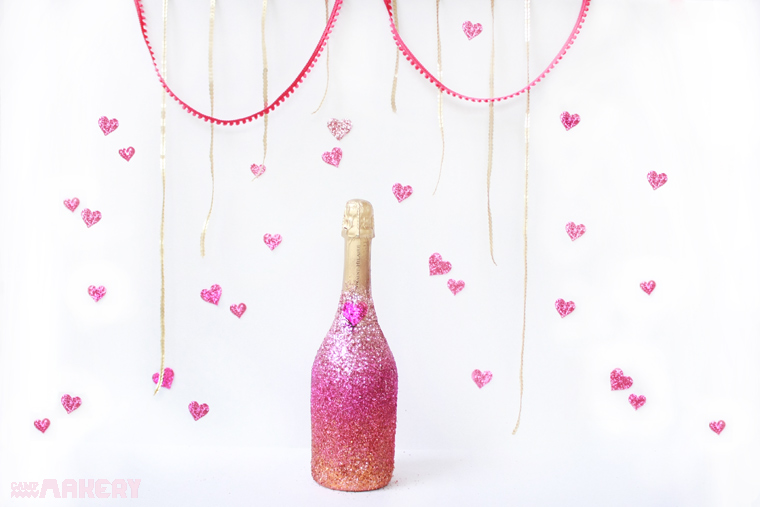 A DIY pink-and-gold-glittered champagne bottle.