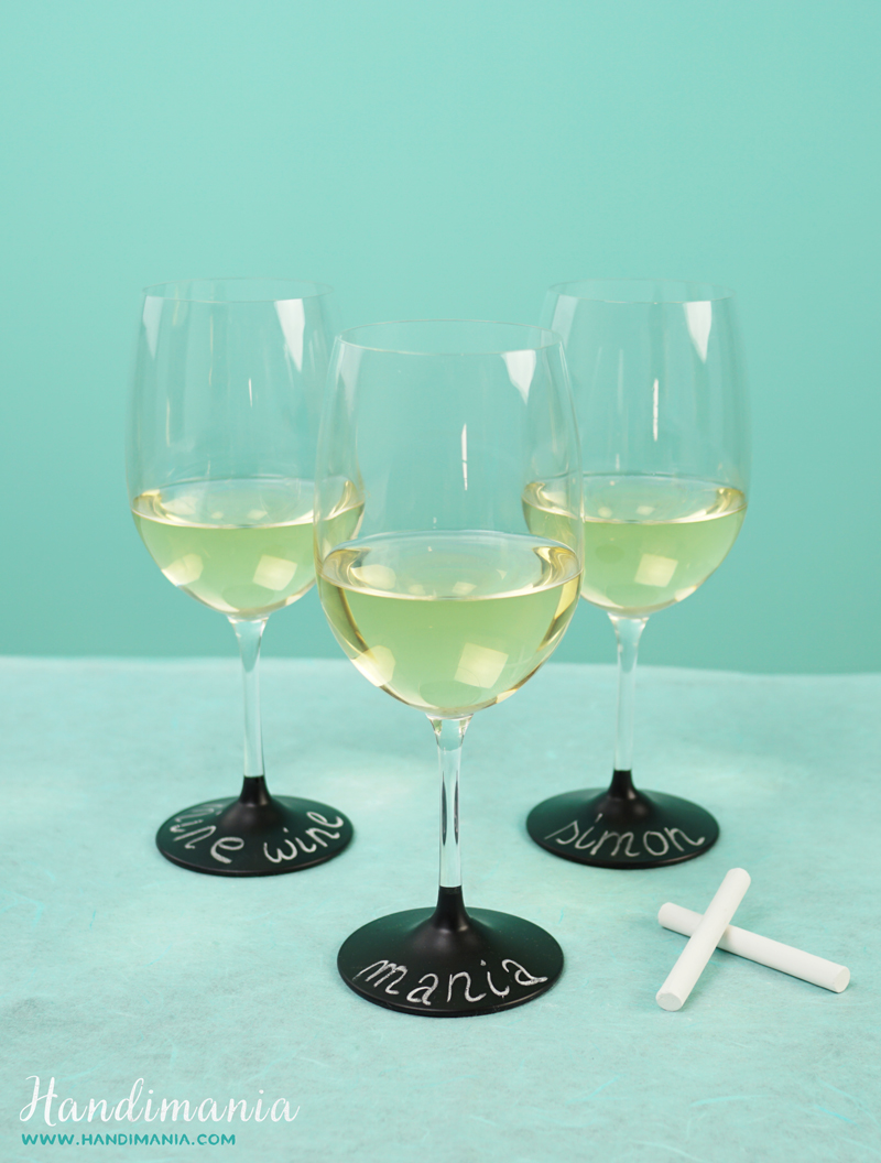 3 DIY chalkboard wineglasses are filled with white wine for a creative New Year's Eve toast.