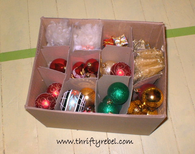 A Christmas ornament holiday decoration storage hack of various ornaments in a wine box from a liquor store.