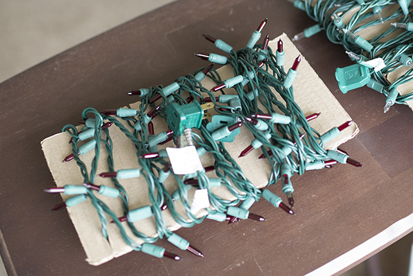 Christmas lights wrapped around a piece of cardboard is a creative holiday storage hack.
