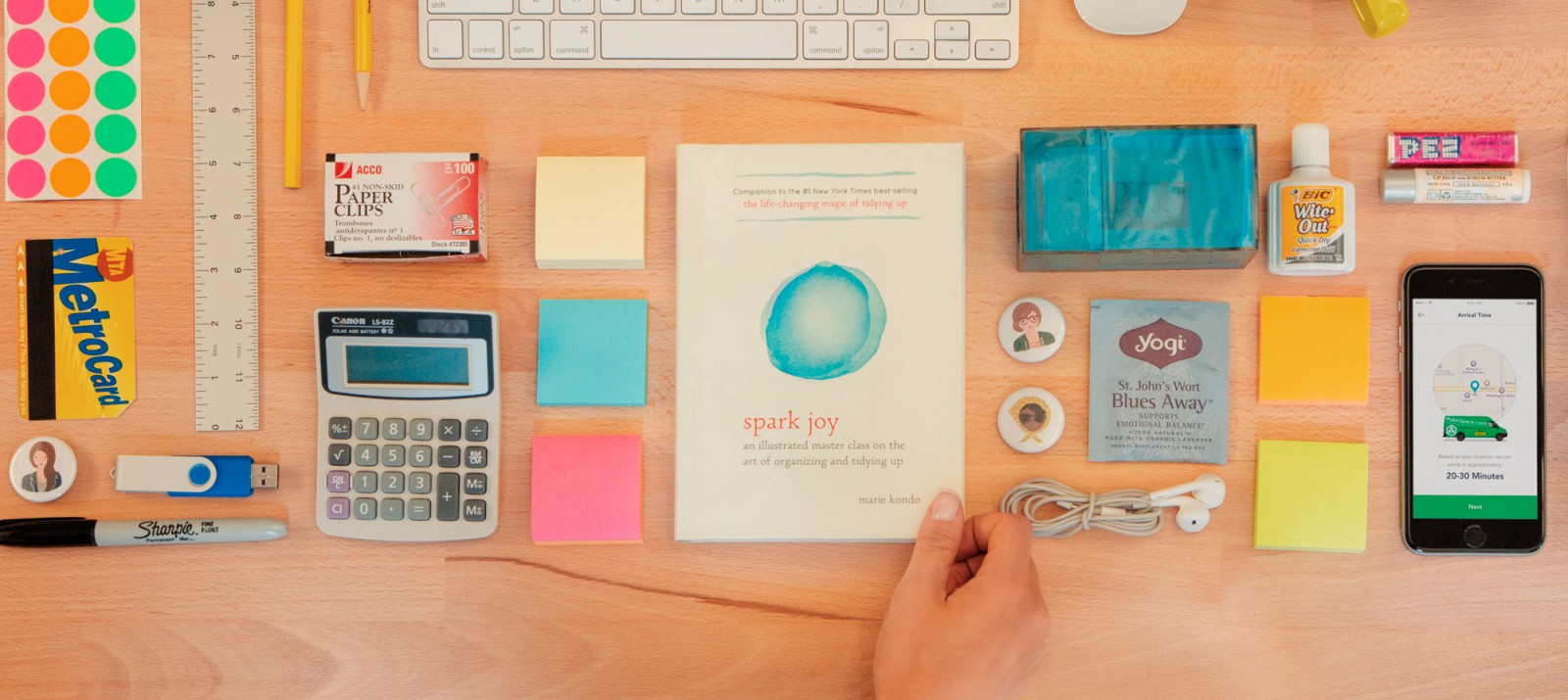 Marie Kondo's new book Spark Joy is on a desk that's organized neatly.
