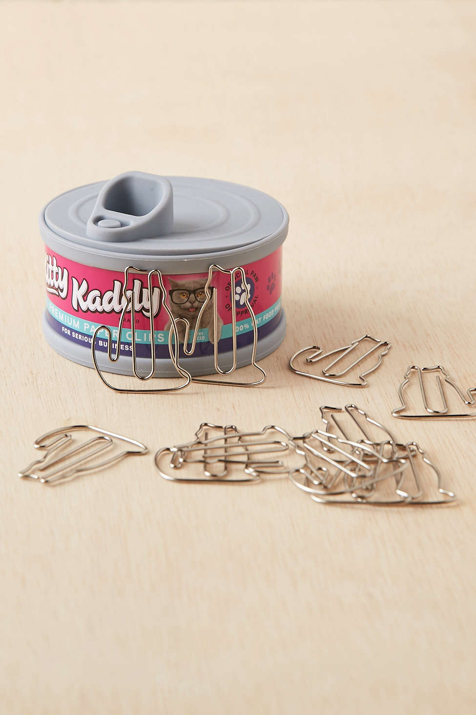 A Kitty Kaddy cat food can that stores paper clips.
