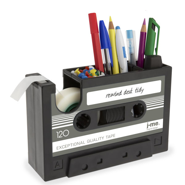 A Rewind Desk tidy, which looks like a black cassette tape, is storing pens, thumbtacks, pencils, and tape.