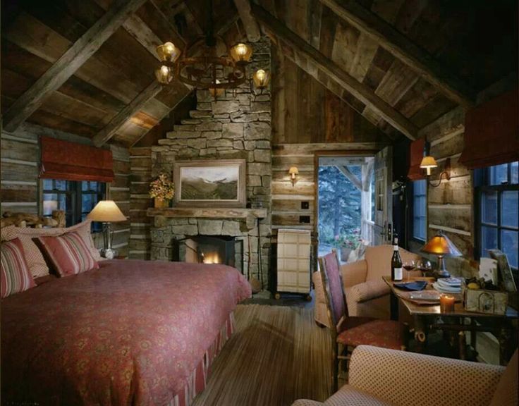 The cozy interior of a log cabin is dimly lit and minimally decorated.