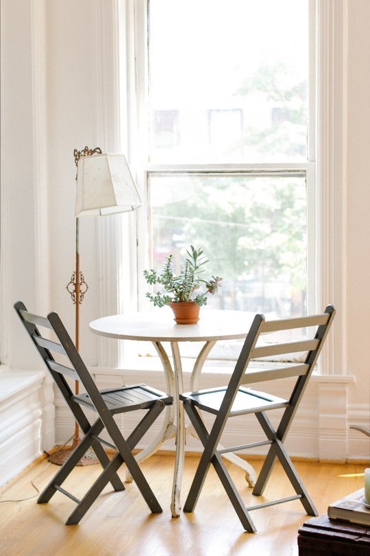 A simple decorating idea to make an apartment look bigger is to use a bistro table as a dining table and desk.