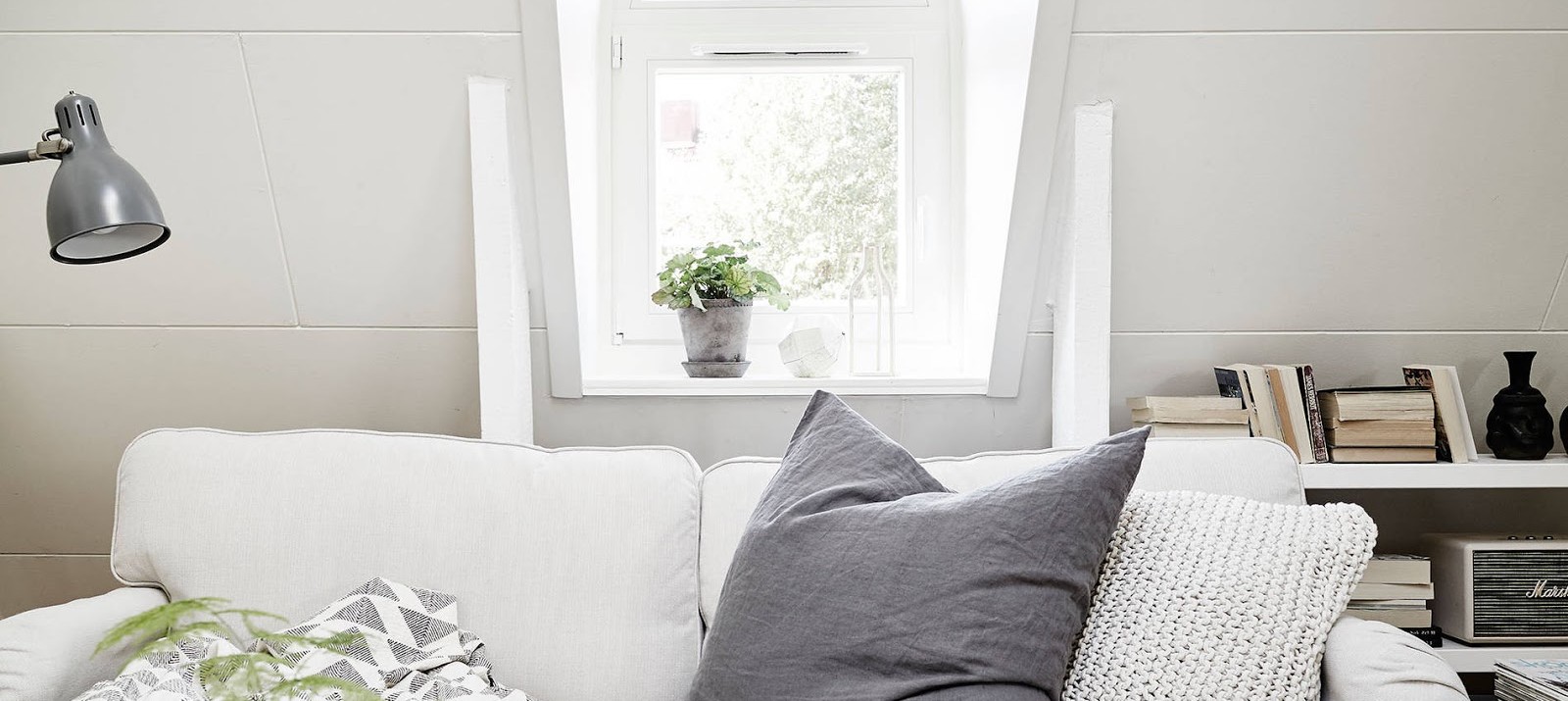 Natural light shines through the window of a tiny apartment in an attic in Stockholm.