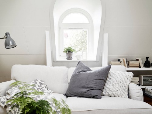 Natural light shines through the window of a tiny apartment in an attic in Stockholm.