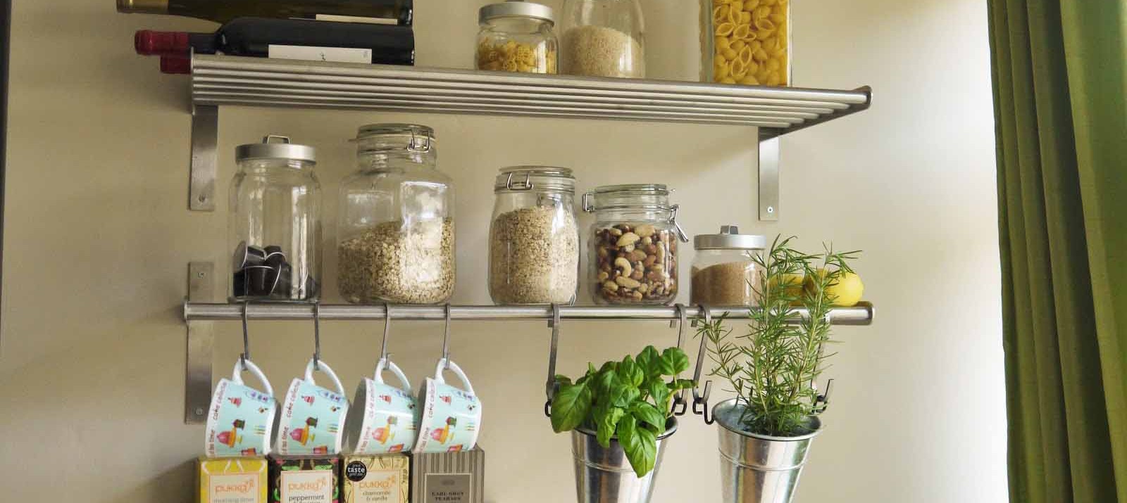 Metal shelves and S hooks used for cheap storage in a small kitchen.