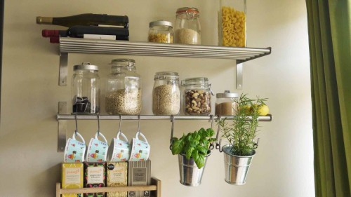 Metal shelves and S hooks used for cheap storage in a small kitchen.