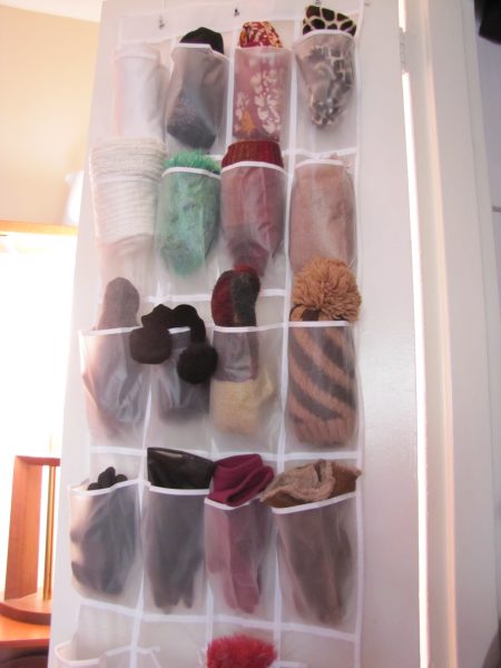 over-the-door shoe organizer storing winter gloves, scarves, and hats