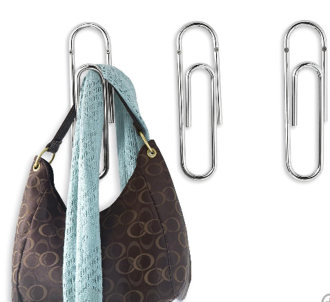 Easy storage ideas: giant paper clips storing a designer bag and scarf.