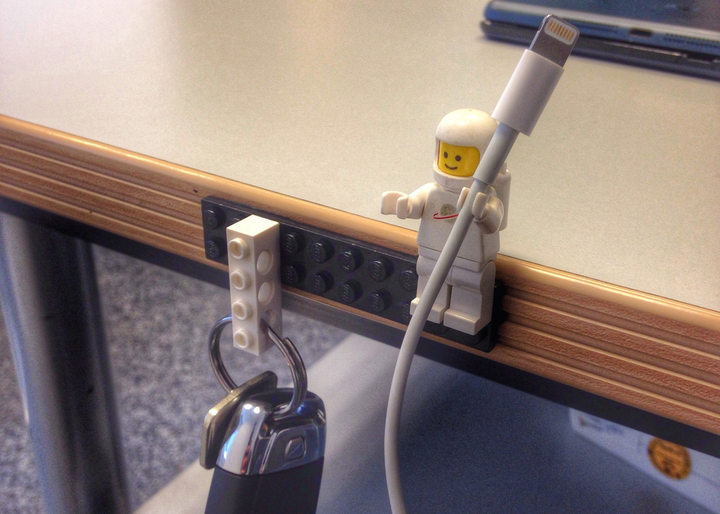 A LEGO piece storing keys and a LEGO man storing an iPhone cable.