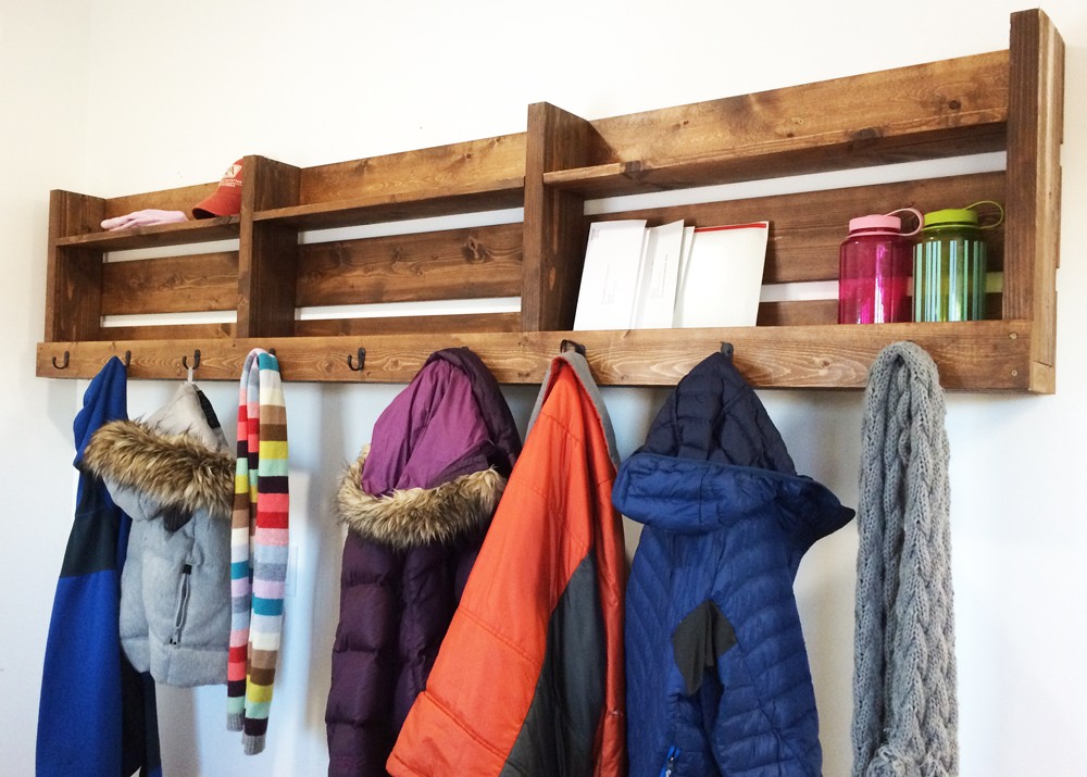 A DIY wood pallet entryway organizer for coats, hats, gloves, scarves, handbags, messenger bags, and backpacks is one of many creative storage ideas for small spaces.