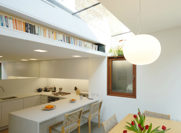 A cool book storage hack for tiny apartments is building bookshelves above a kitchen.