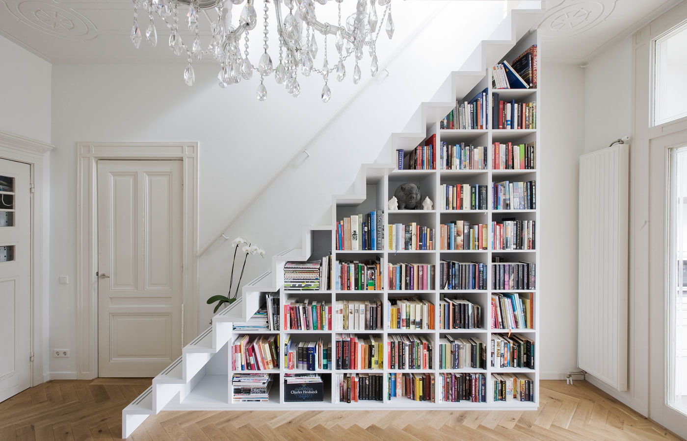 A DIY bookcase in a staircase is one of many creative book storage hacks for small apartments.