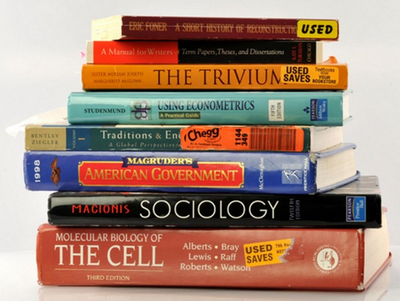 A stack of used college textbooks including Molecular Biology of the Cell, Macionis Sociology, Macgruder's American Government, and more. 