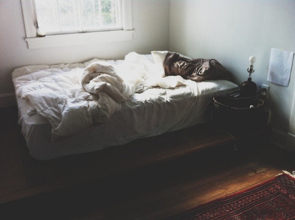 Beat cabin fever: place a bed near a window in a tiny apartment.