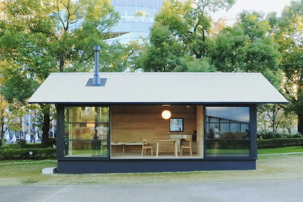 The exterior of a MUJI Wooden Hut, a minimal tiny house in Japan.