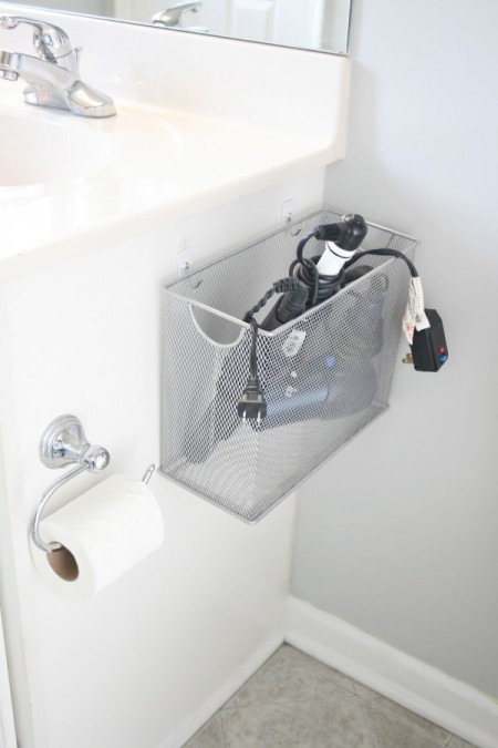 a file organizer is perfect for storing a hairdryer and straightener on the side of a bathroom sink