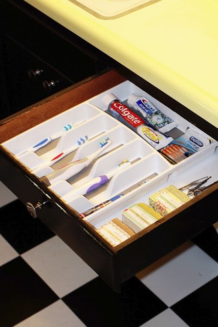 an organizer tray declutters a bathroom sink drawer