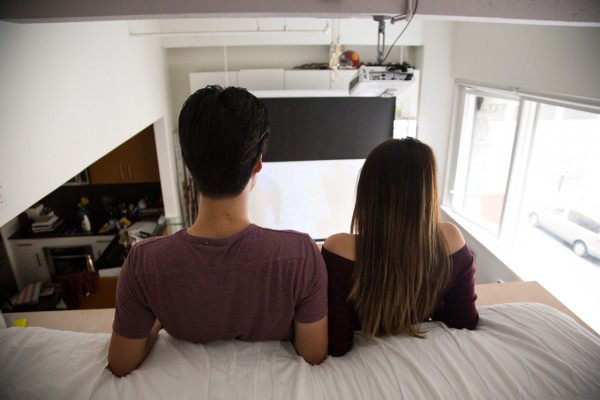 Donnie and Nicki Wang relax on the Domino Loft system's bed in their beautiful 500-square-foot San Francisco condo, which also has a home theater.