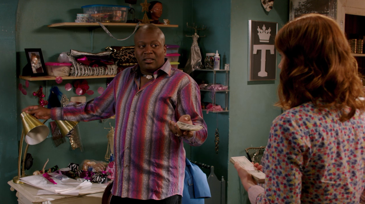 Titus from Unbrakable Kimmy Schmidt using shelves, hooks, and Tupperware to store ribbons and cloth in his NYC apartment is a cheap storage and organizing solution.