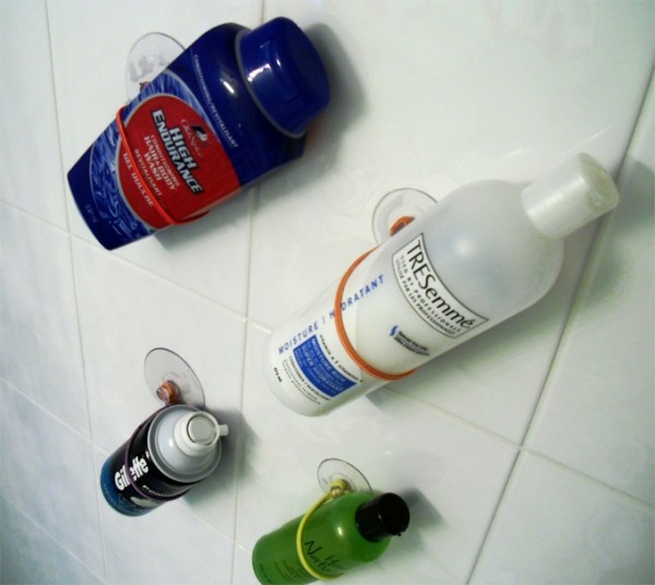 diy shower storage hacks made from suction cups and hair ties are storing body wash, hair products, and gillette shaving cream
