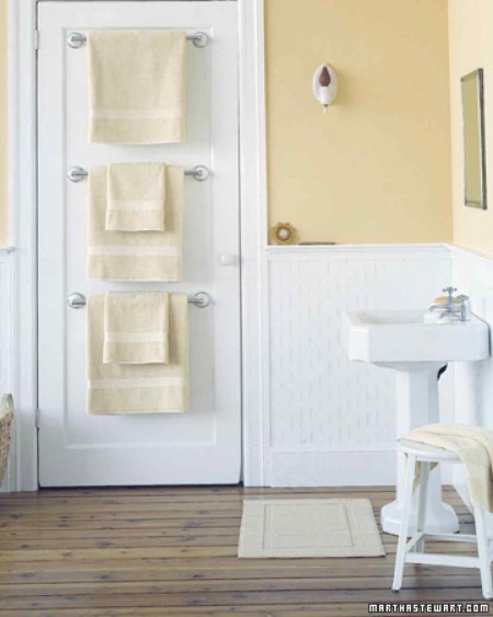 martha stewart's towel bar trio mounted on the back of a bathroom door