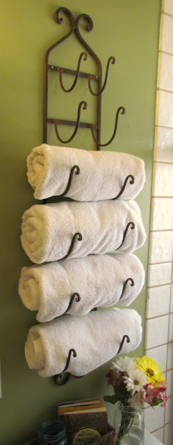 a wine rack repurposed to store four white towels