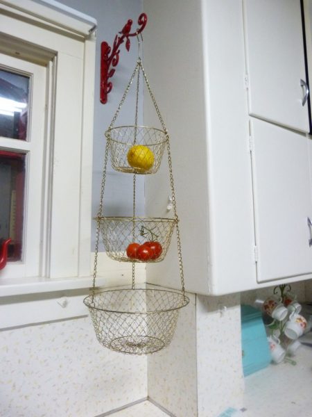produce storage solution: hang 3-tiered wire baskets on a hook in the kitchen