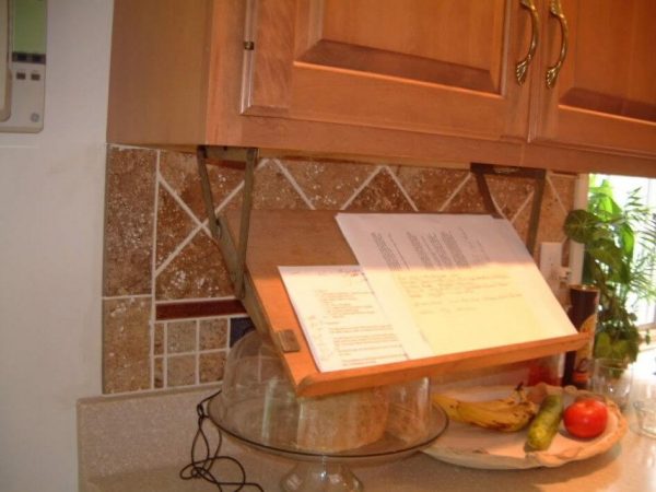 cookbook storage hack: retractable bookstand mounted underneath a kitchen cabinet