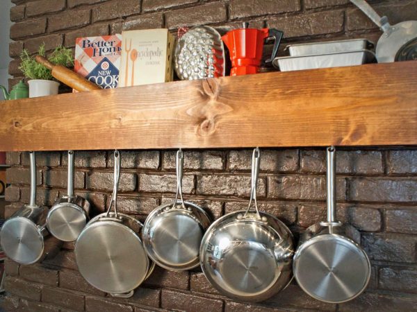 a wall-mounted wooden pot and pan rack by sam henderson is one of many genius storage hacks for small spaces